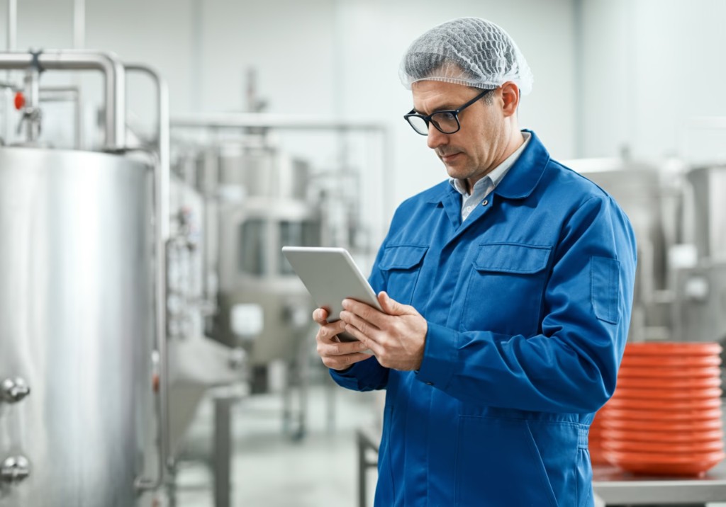 Manufacturing team member reviewing QA Trace on a tablet on the production floor